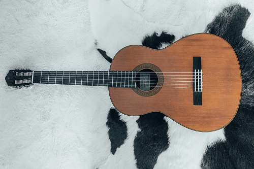 leisure activities brown acoustic guitar on white and black textile musical instrument